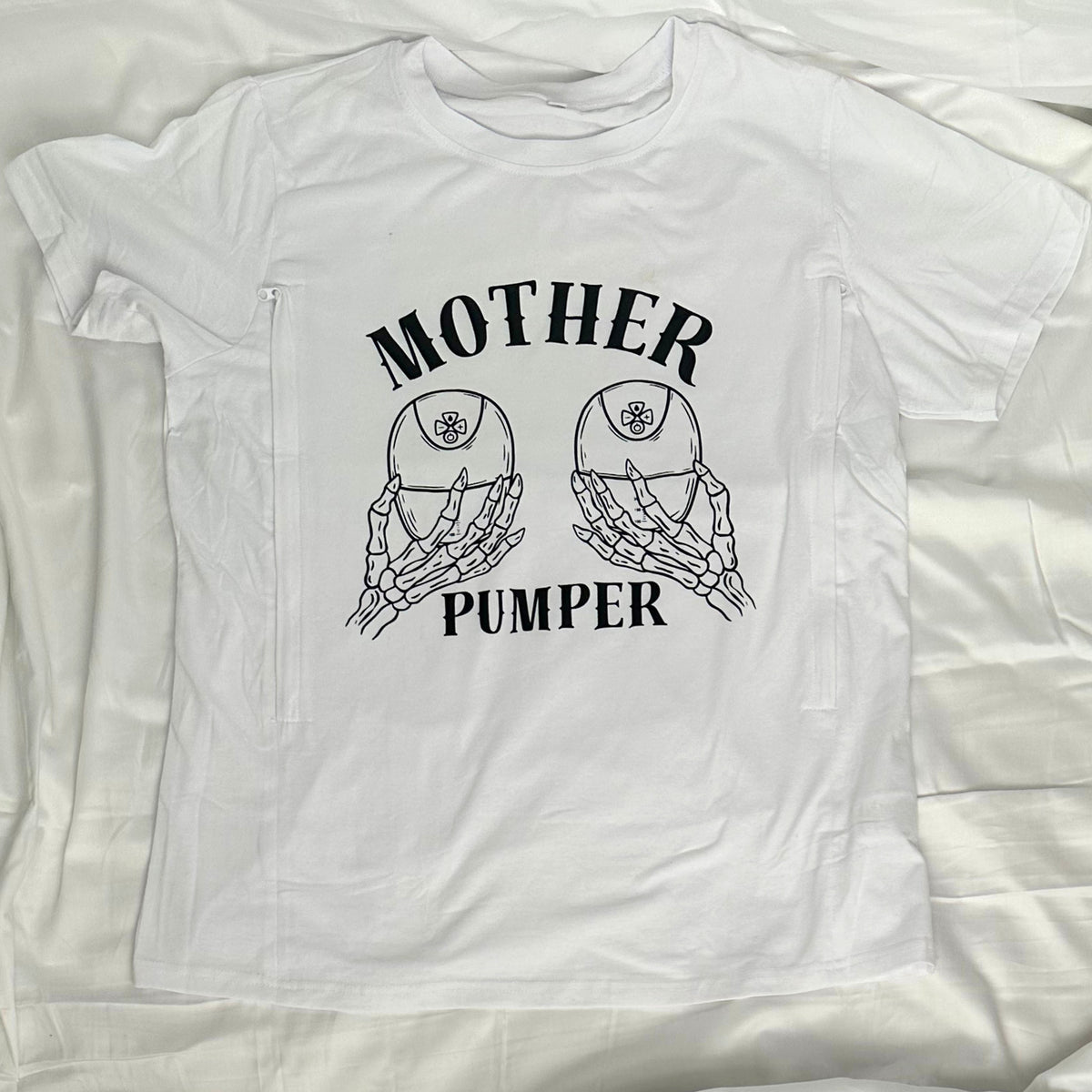 White graphic shirt with two wearable pumps featured and skeleton hands holding the pumps. "Mother Pumper" design.